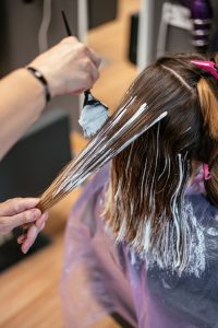 Hairdresser dyeing a woman's hair